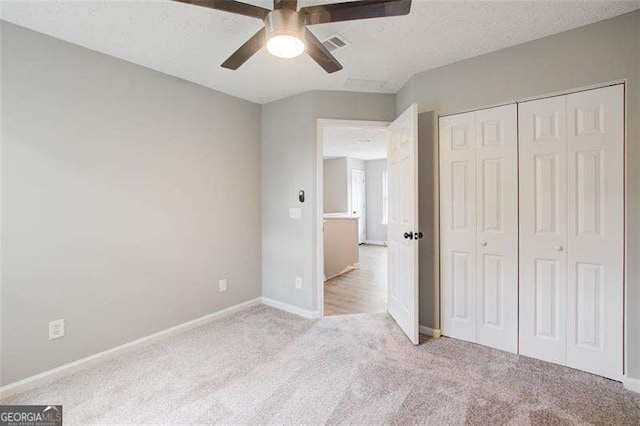 unfurnished bedroom with a closet, a textured ceiling, visible vents, and carpet flooring