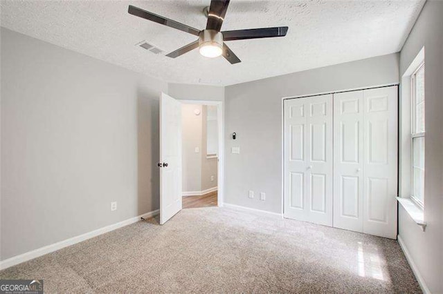 unfurnished bedroom with a textured ceiling, a closet, and baseboards