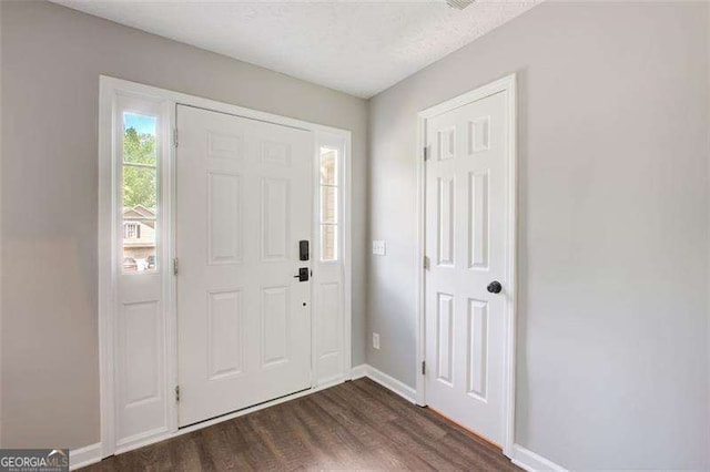 foyer featuring dark wood-style floors and baseboards