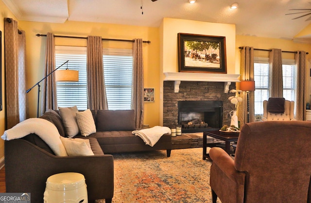 living area featuring a fireplace, ornamental molding, and a ceiling fan