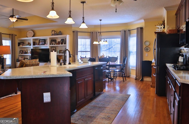 kitchen with black appliances, crown molding, wood finished floors, and ceiling fan with notable chandelier