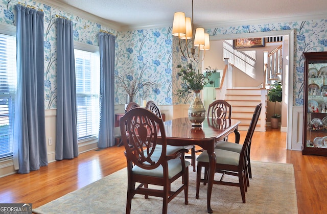 dining space featuring wallpapered walls, plenty of natural light, ornamental molding, and a textured ceiling