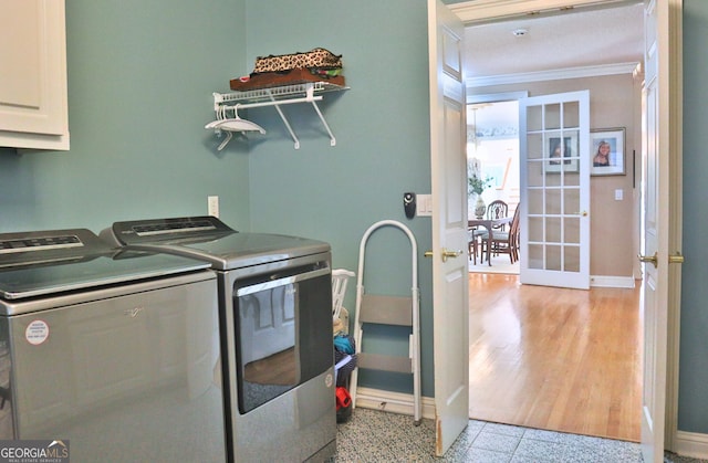 washroom featuring baseboards, french doors, cabinet space, washing machine and clothes dryer, and crown molding