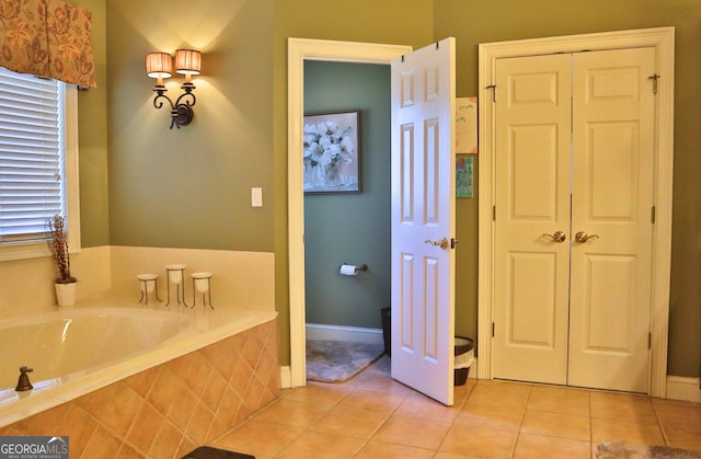 full bath with a wealth of natural light, tile patterned flooring, a closet, and a bath