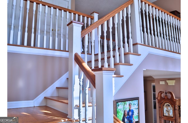 stairs with crown molding and baseboards