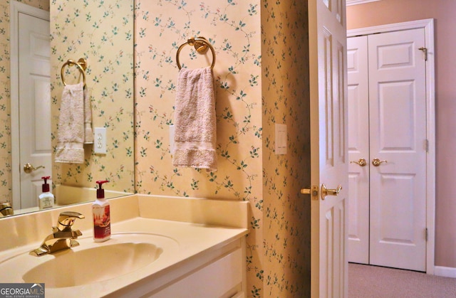 bathroom featuring vanity and wallpapered walls