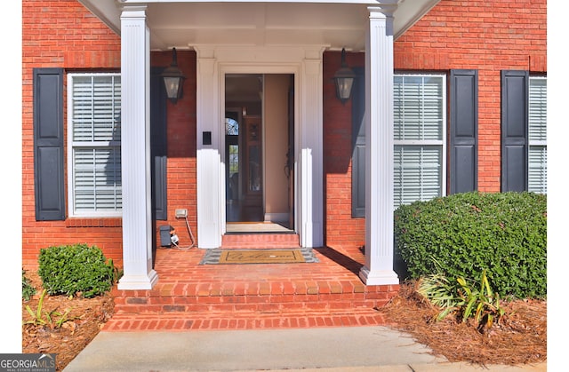 doorway to property with brick siding