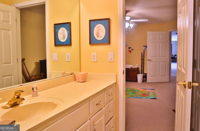 bathroom with a textured ceiling, a ceiling fan, and vanity