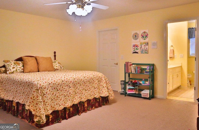 carpeted bedroom with ceiling fan and ensuite bath