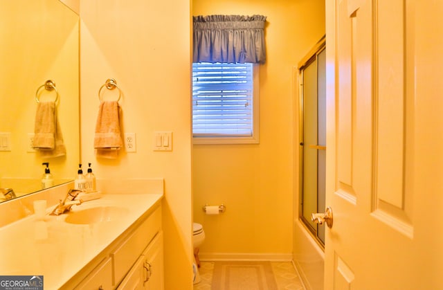 full bath featuring baseboards, bath / shower combo with glass door, toilet, tile patterned flooring, and vanity