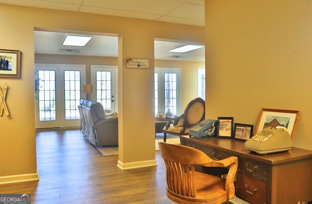 office space featuring visible vents, wood finished floors, a paneled ceiling, and baseboards