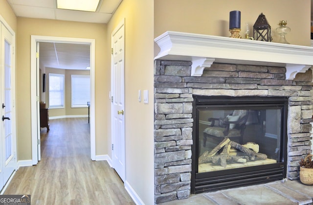 details with a fireplace, baseboards, and wood finished floors