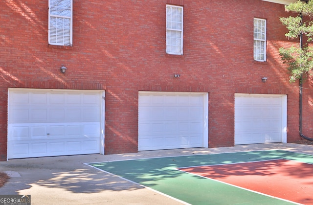 exterior space with a garage and brick siding