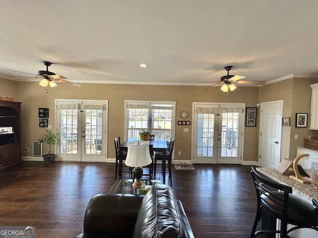 living room with dark wood-type flooring, french doors, crown molding, and baseboards