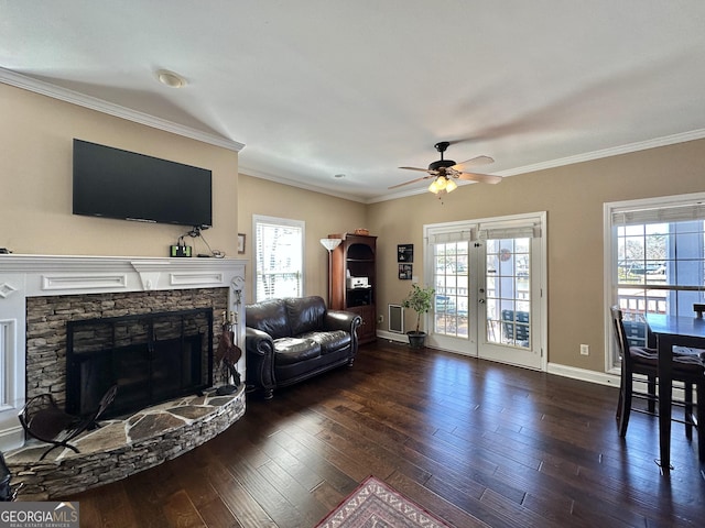 living area with baseboards, dark wood-style flooring, a fireplace, and crown molding