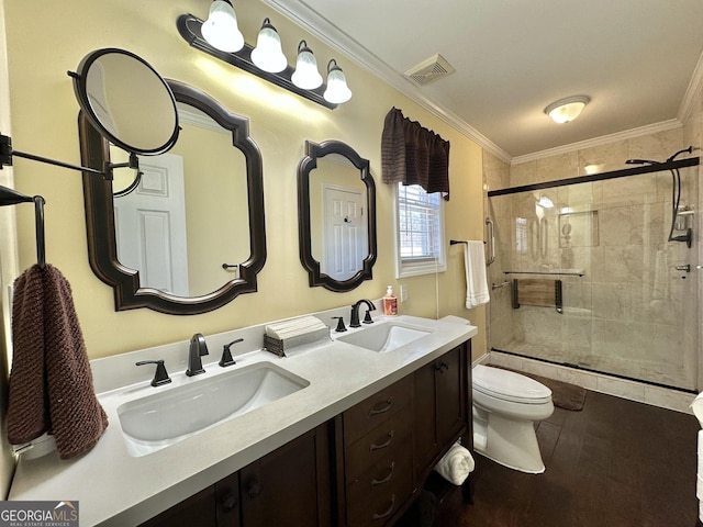 full bathroom featuring toilet, crown molding, a sink, and a shower stall