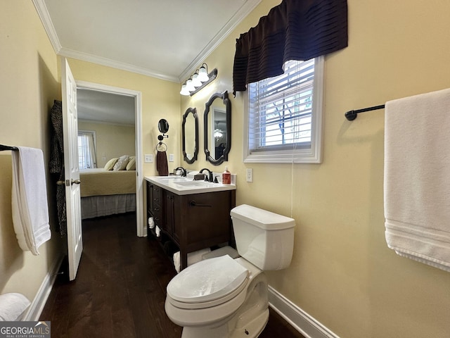 bathroom featuring ensuite bathroom, wood finished floors, vanity, baseboards, and crown molding