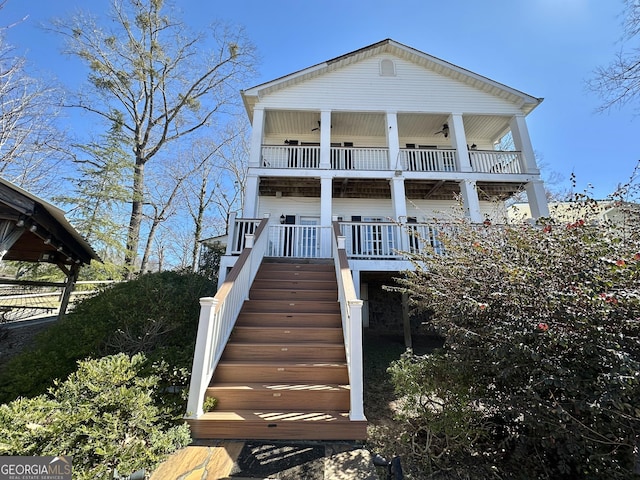 view of front of property with stairs, a porch, and a balcony