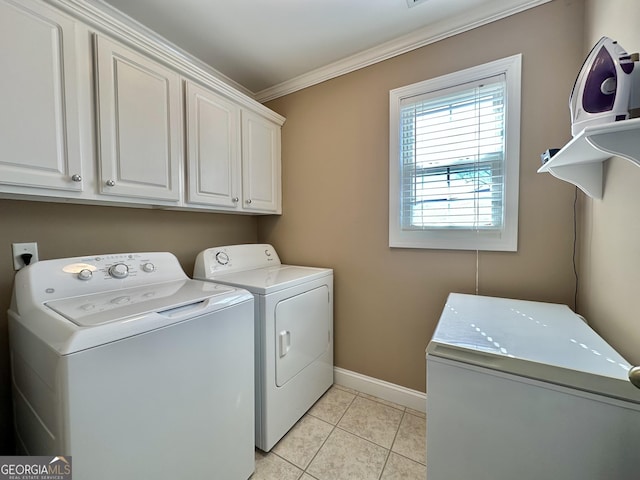 laundry room with crown molding, cabinet space, light tile patterned flooring, washer and dryer, and baseboards