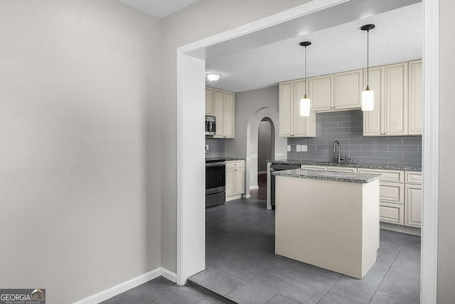 kitchen with dishwashing machine, electric stove, stainless steel microwave, and cream cabinetry