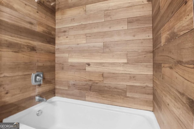 full bath with wood walls and shower / bathtub combination