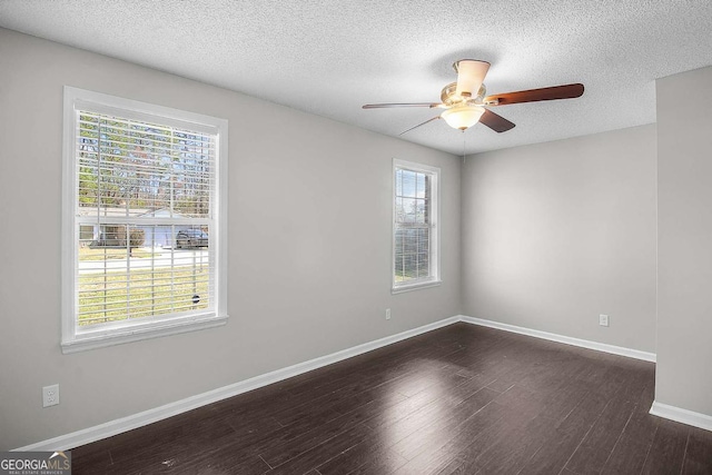 unfurnished room featuring dark wood-style floors, a ceiling fan, baseboards, and a textured ceiling