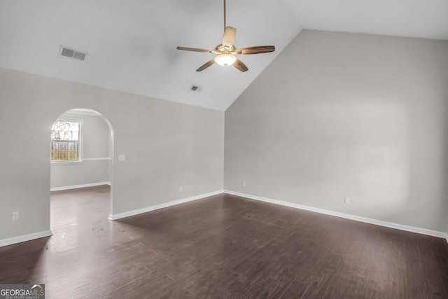 empty room with dark wood-style floors, arched walkways, visible vents, and ceiling fan