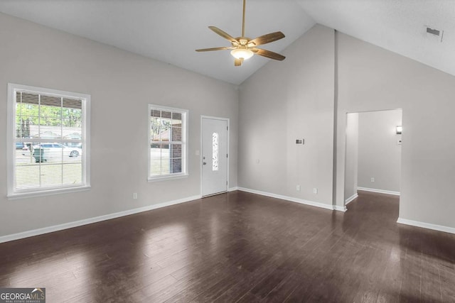 interior space with dark wood-style floors, high vaulted ceiling, and baseboards