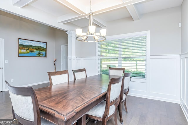 dining space with dark wood-style flooring, a chandelier, a decorative wall, and beam ceiling