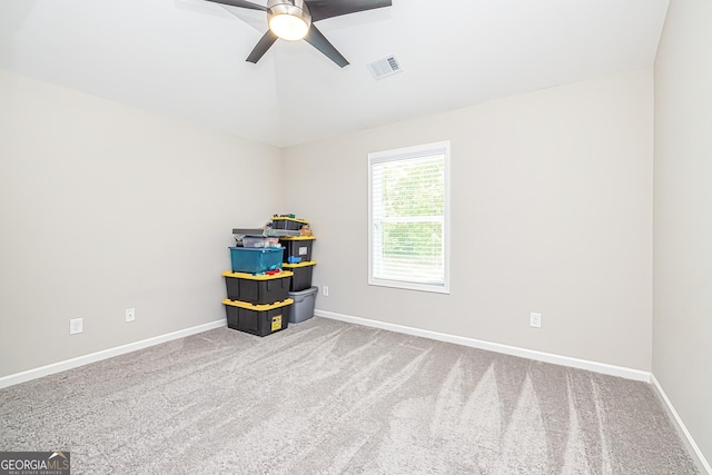 carpeted spare room featuring ceiling fan, visible vents, and baseboards