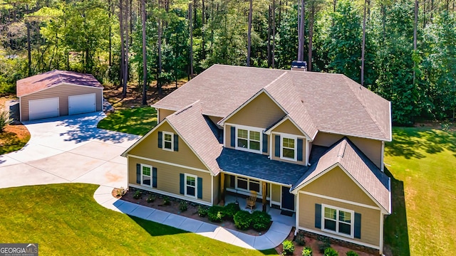 craftsman-style house with a garage, roof with shingles, an outbuilding, covered porch, and a front lawn