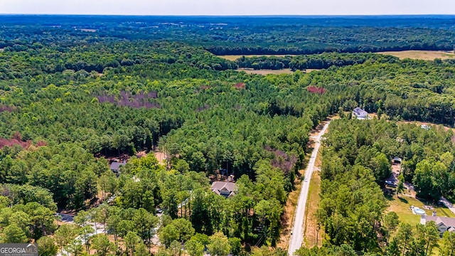 birds eye view of property featuring a view of trees