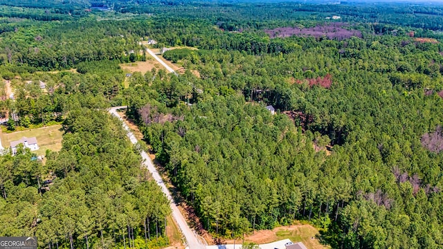 birds eye view of property featuring a view of trees