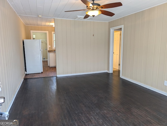 spare room with ceiling fan, wood-type flooring, and baseboards