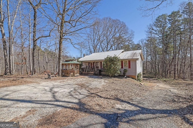 view of front of property featuring metal roof and dirt driveway