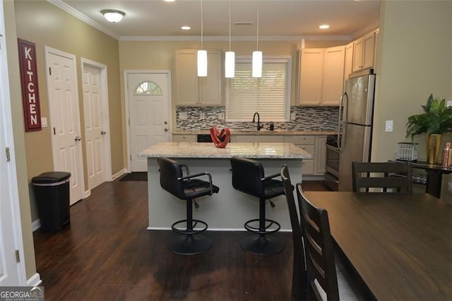 kitchen with a kitchen island, a sink, freestanding refrigerator, dark wood-style floors, and crown molding