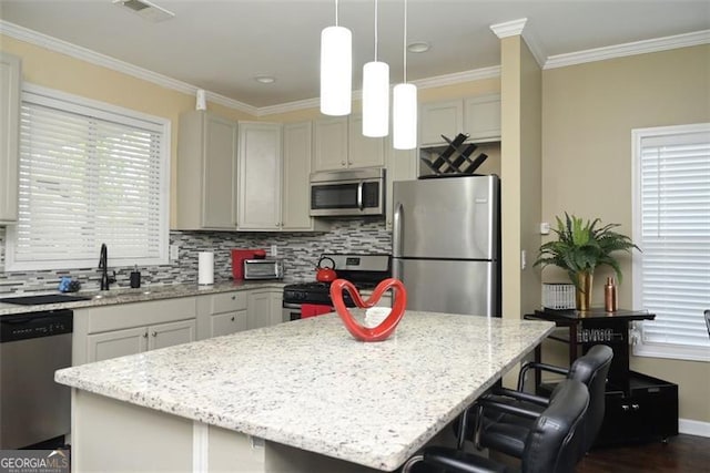 kitchen featuring stainless steel appliances, tasteful backsplash, visible vents, ornamental molding, and a kitchen island