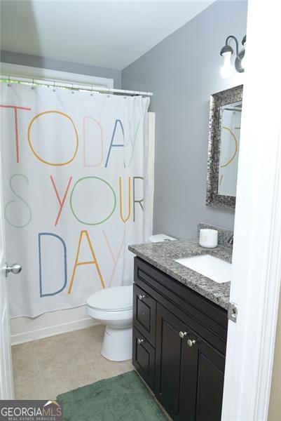 full bathroom featuring baseboards, vanity, and toilet