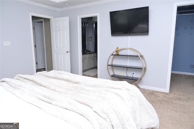 carpeted bedroom featuring a closet, a spacious closet, ornamental molding, ensuite bath, and baseboards