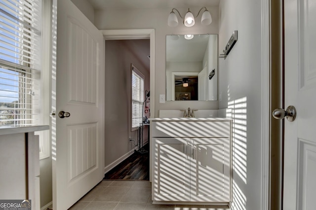 bathroom with a ceiling fan, a sink, baseboards, and tile patterned floors