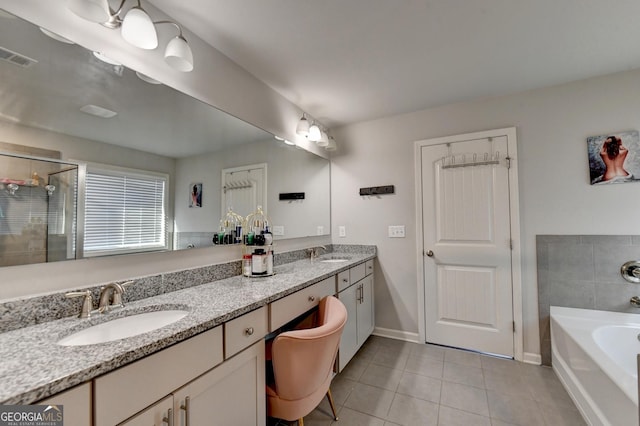 bathroom with double vanity, a bath, a sink, and tile patterned floors