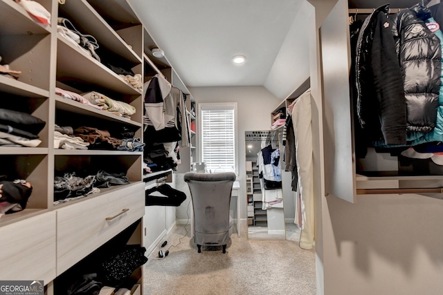 spacious closet with lofted ceiling and light carpet