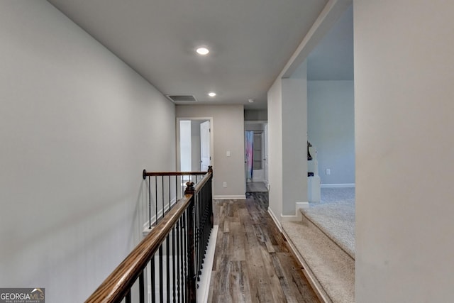 hallway featuring recessed lighting, visible vents, an upstairs landing, wood finished floors, and baseboards