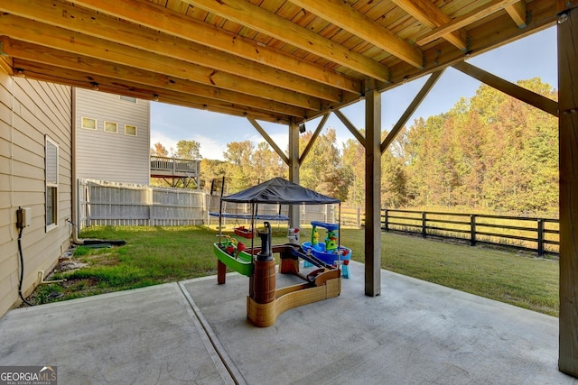 view of patio featuring a trampoline and a fenced backyard