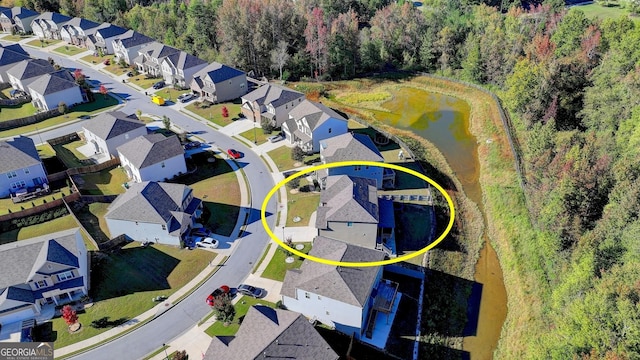 birds eye view of property with a water view, a residential view, and a wooded view