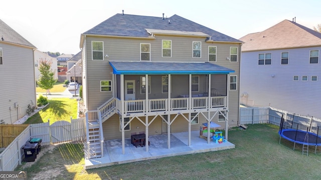 back of house with a lawn, a patio, a sunroom, a trampoline, and a gate