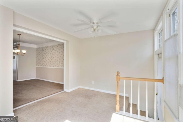 carpeted empty room with ceiling fan with notable chandelier, wallpapered walls, and baseboards