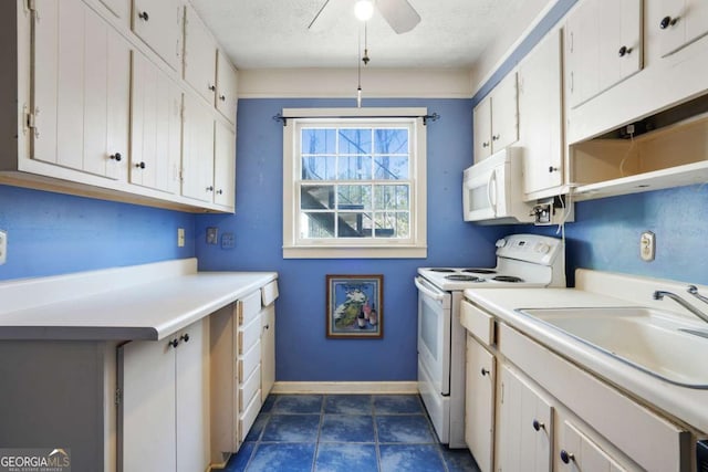 laundry area featuring a sink, a textured ceiling, ceiling fan, dark tile patterned floors, and baseboards