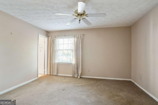 carpeted empty room with a textured ceiling, ceiling fan, and baseboards