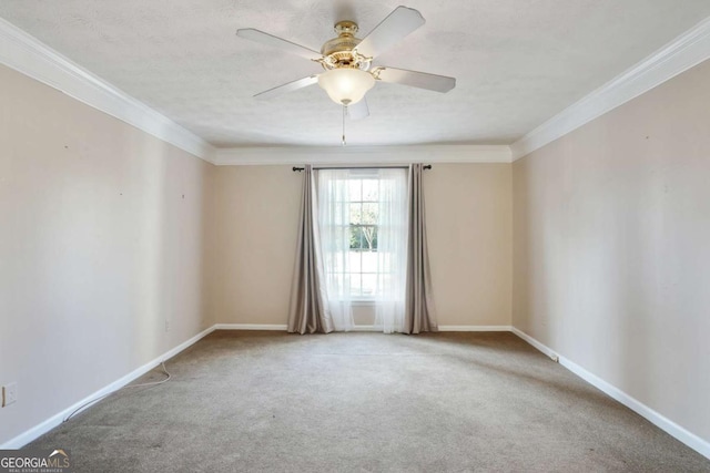 spare room featuring ceiling fan, a textured ceiling, carpet flooring, baseboards, and crown molding